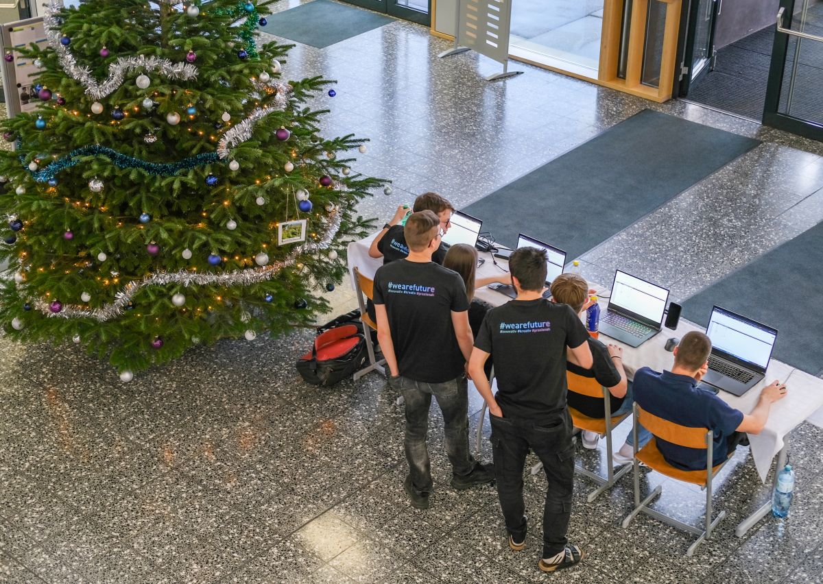Blick von oben in die Aula: Schüler an Laptops