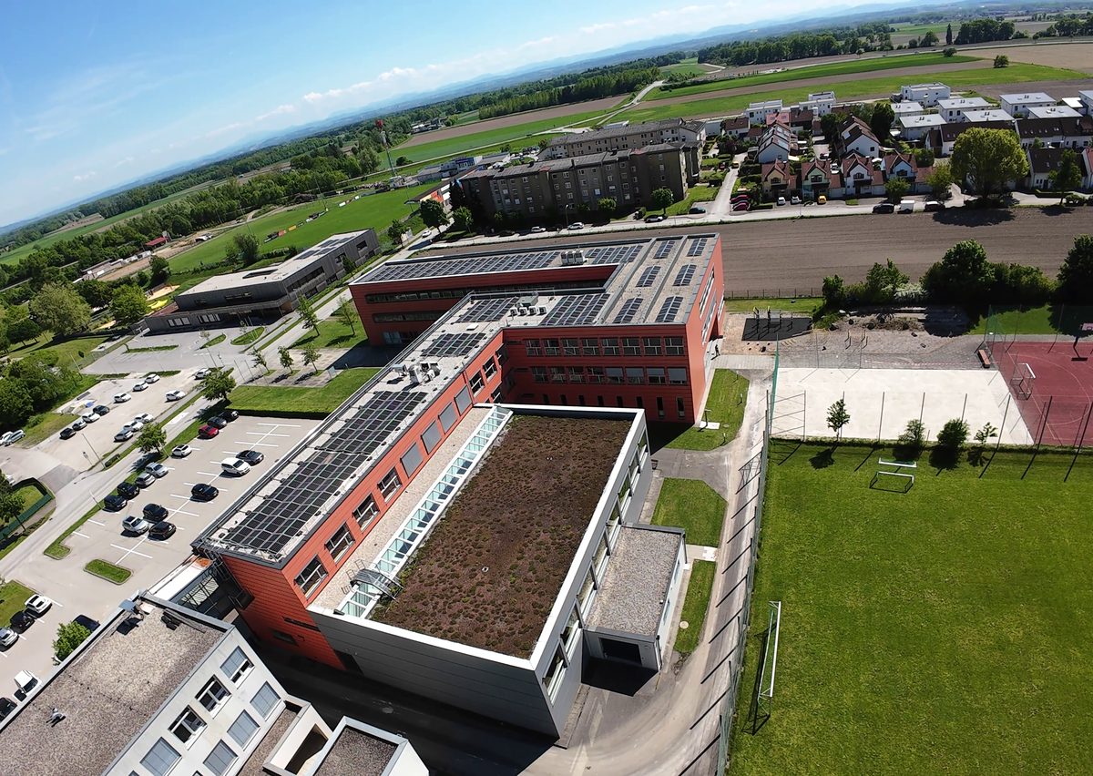 Drohnenfoto der HTL Perg mit begrüntem Dach, Photovoltaik und Sportplätzen