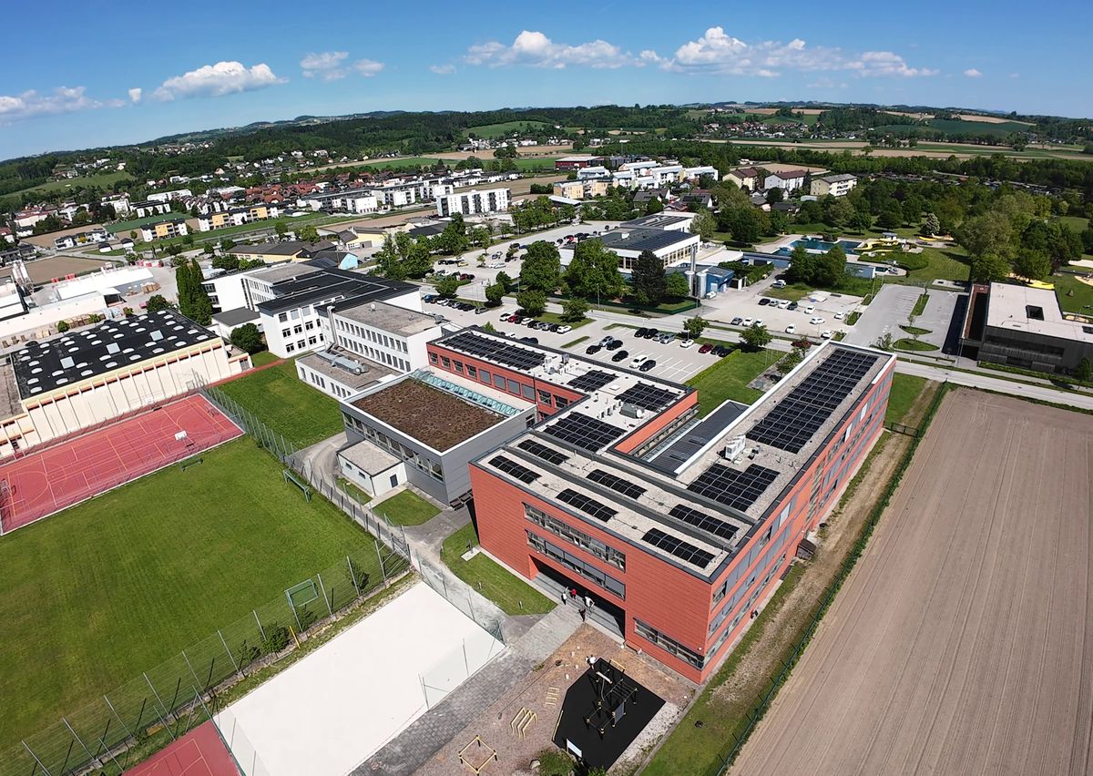 Drohnenfoto der HTL Perg mit Schulgebäude, Photovoltaik am Dach und Sportplätzen