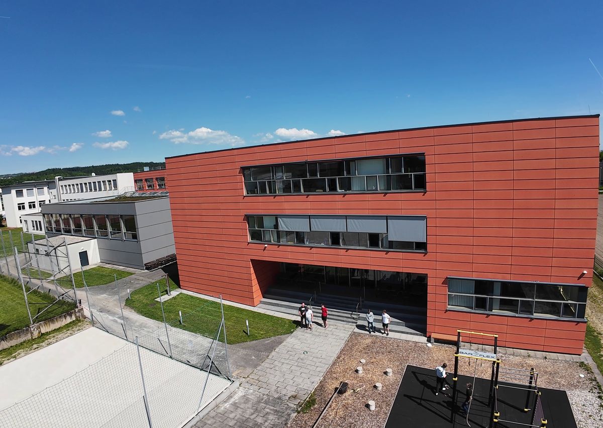Drohnenfoto: rote Fassade und Haupteingang der HTL Perg