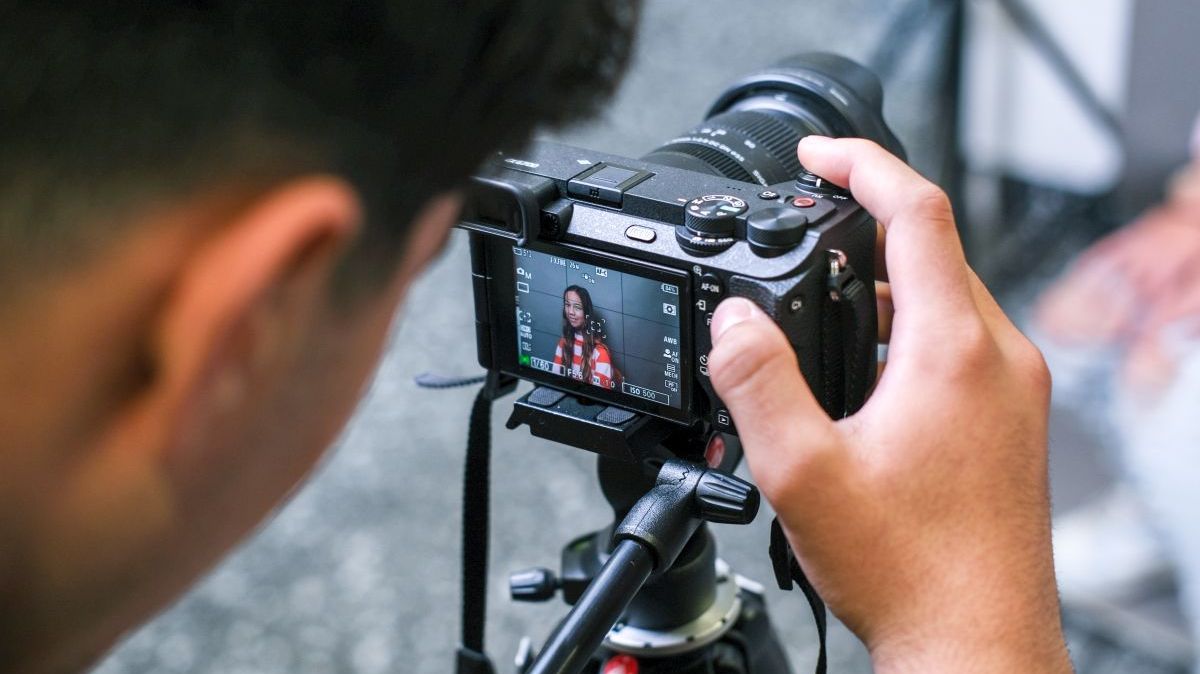 Schüler filmt mit einer Systemkamera auf dem Stativ