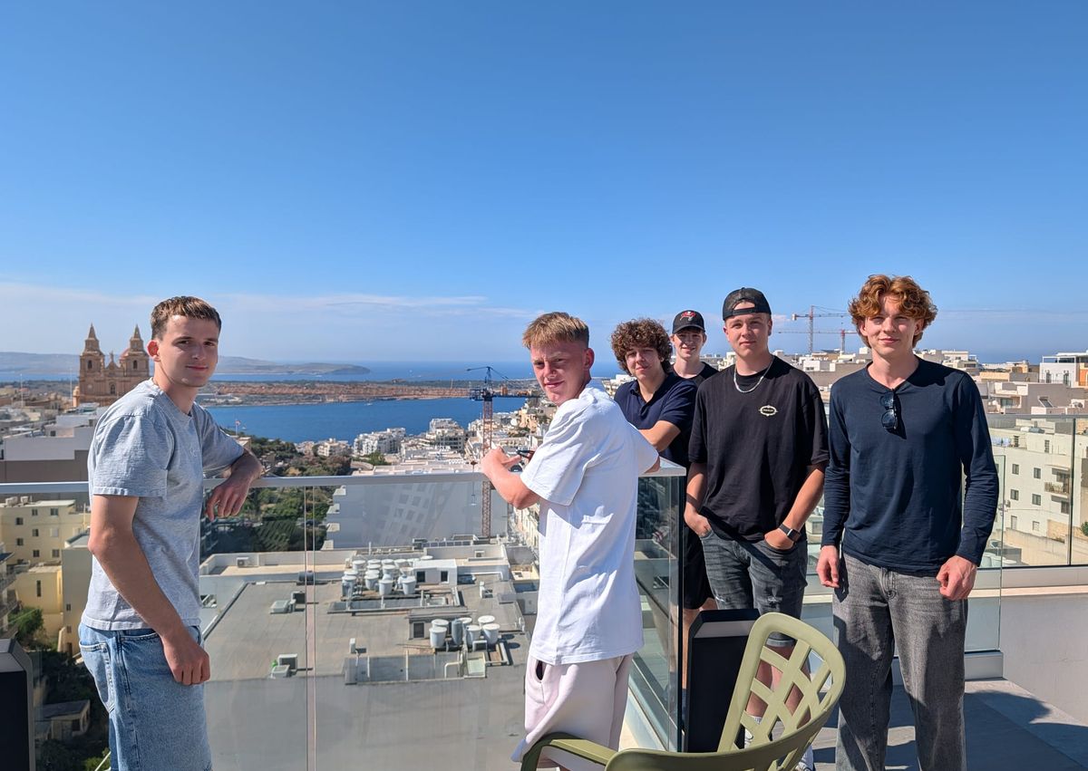 Schüler auf einer Dachterrasse mit Blick über Malta