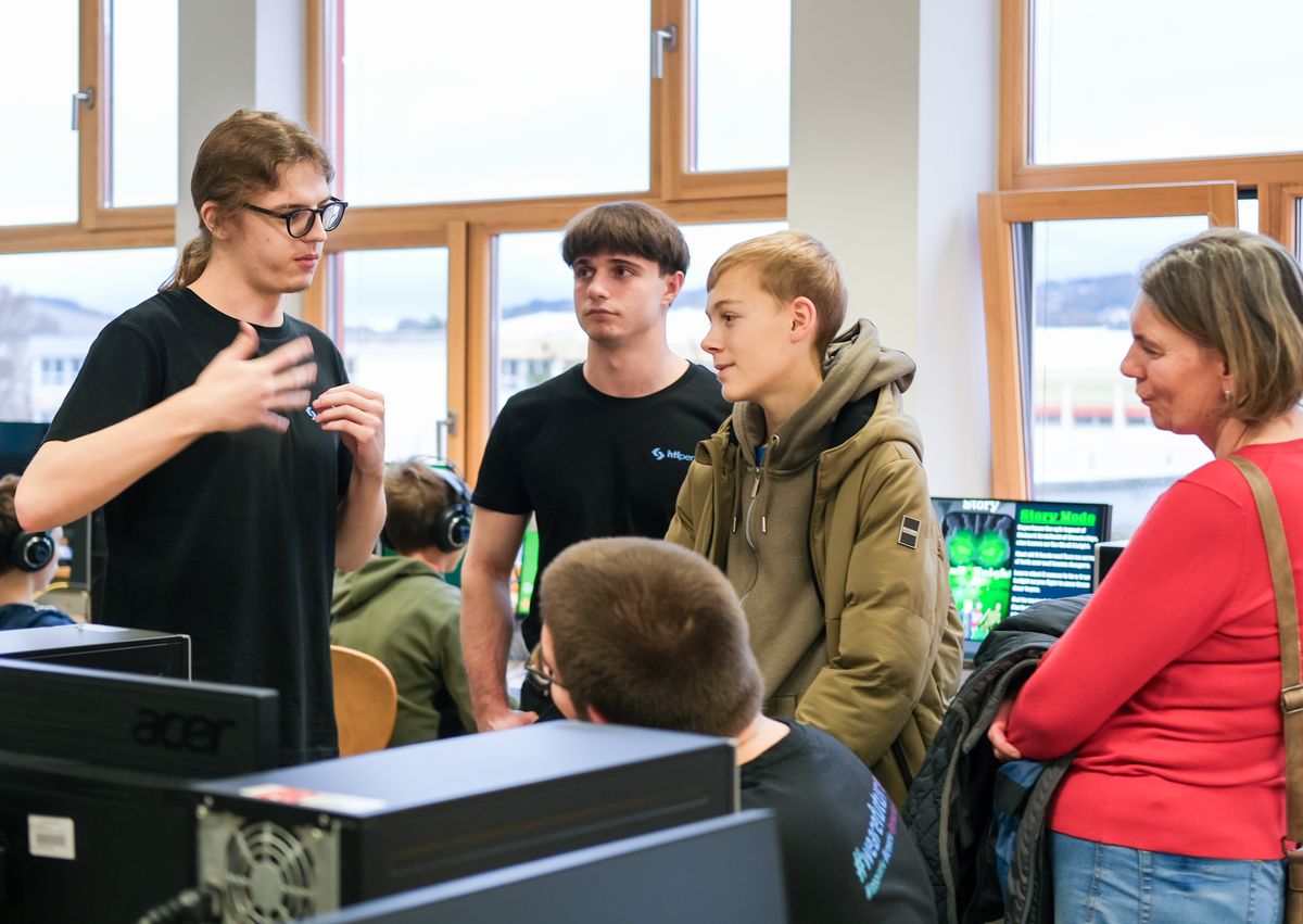 Schülerin erklärt Besucher:innen ein Spieleprojekt