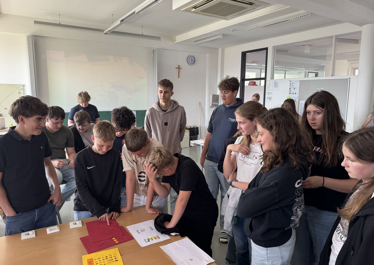 Schüler:innen testen Papier-Prototypen am Tisch